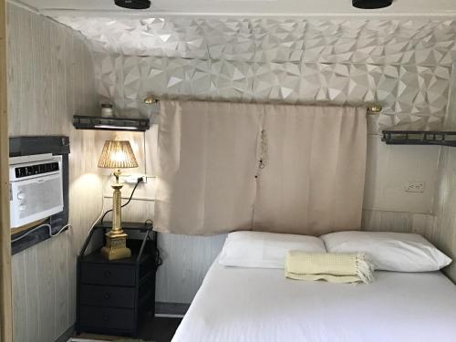 a bedroom with a white bed and a lamp at Tim Vales place in Tampa