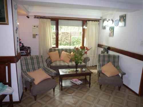 sala de estar con sofá, 2 sillas y mesa en Chalet familiar adosado Roses Rojas en Villa Gesell