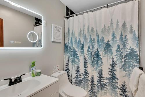 a bathroom with a shower curtain with pine trees at Luxury Mountain Villa - 3 bedroom, hot-tub, fire-pit in Hunter