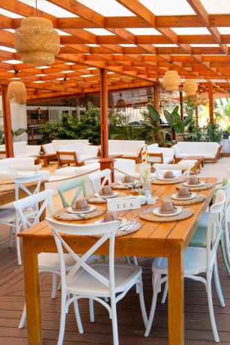 a wooden table and chairs on a patio at KoKo Beach - Wooden Green House in Vila Praia Do Bilene