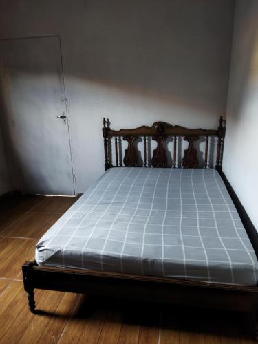 a bed with a wooden frame in a room at Cantinho da Flor in Barretos