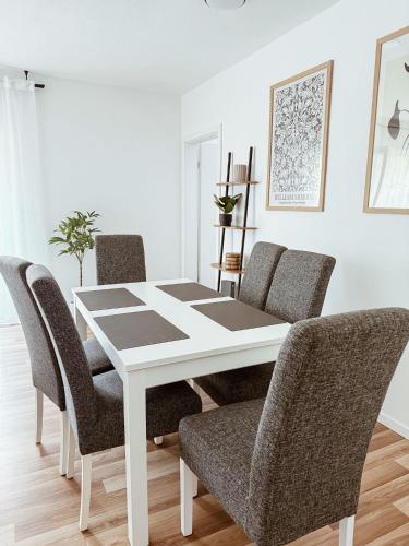 a dining room table with chairs and a white table at FeWo Reimer in Horn-Bad Meinberg