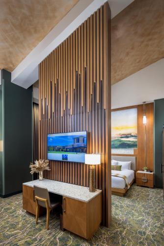 a hotel room with a bed and a desk and a tv at Golden Mesa Hotel in Guymon