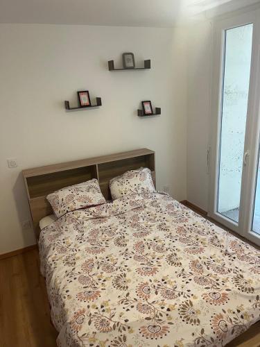 a bedroom with a bed and two pillows and a window at Le Nid de la Distillerie in Hérépian