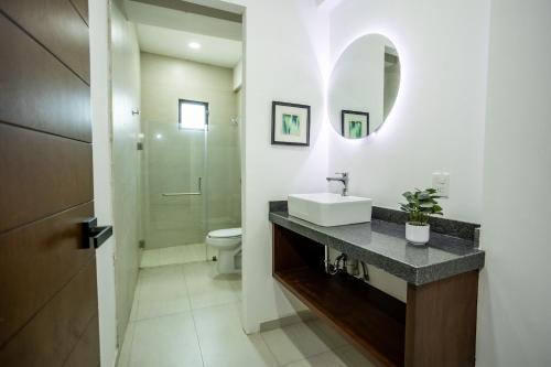 a bathroom with a sink and a toilet and a mirror at Suites Santa Isabella in Ajijic