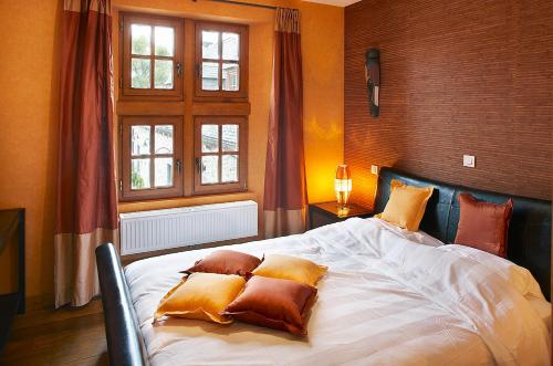 a bedroom with a large bed with pillows on it at Château-ferme de Pondrome in Beauraing