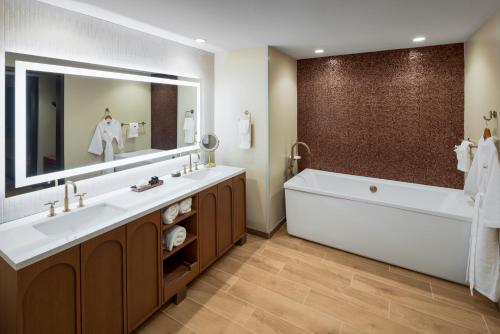 a bathroom with a large tub and a large mirror at Golden Mesa Hotel in Guymon