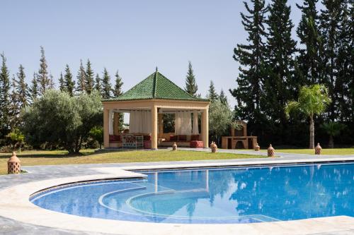 a swimming pool with a gazebo in a yard at Villa privée, 5 suites, Piscine & Jardin XXL in Marrakesh