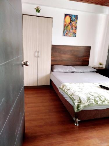 a bedroom with a bed and a closet and a door at Apartaestudio confortable 1 en Combia in Pereira