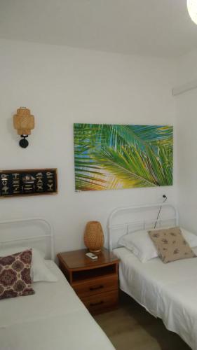 a bedroom with two beds and a table with a picture at Studio apartman Marija 2 in Bol