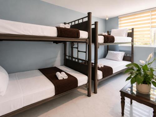 a room with three bunk beds and a table at Hotel Boutique Venecia Cdmx in Mexico City