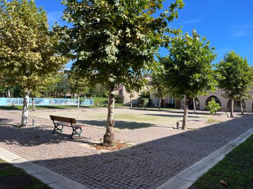 a park with a bench and trees on a sidewalk at Lake view Appartment in Monflanquin