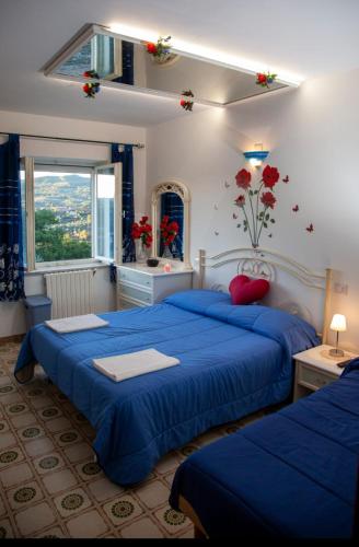 a bedroom with two blue beds and a window at La Terrazza di Laurino in Laurino