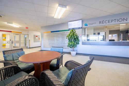a waiting room with a table and chairs at Résidences du Cégep de Rimouski in Rimouski
