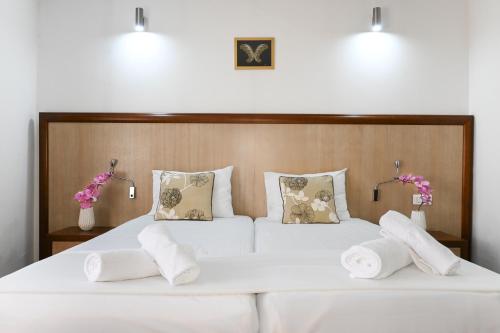 a bedroom with a white bed with white sheets and pillows at City5 ROOMS & SUITES by LSA in Skopje