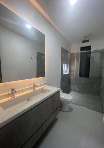 a bathroom with a sink and a toilet and a mirror at Casa Aqua in Nilo