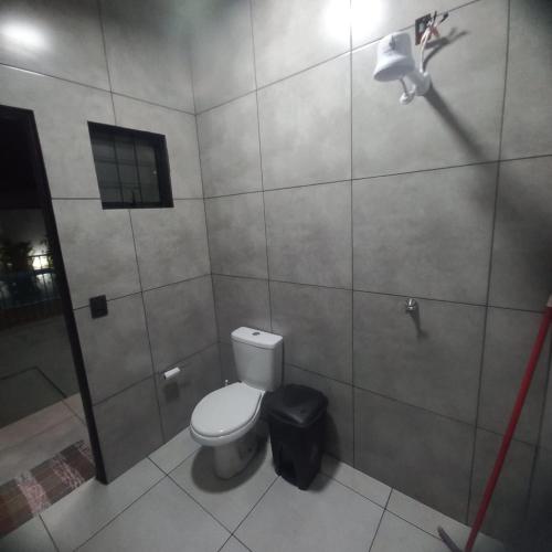 a bathroom with a toilet and a trash can at Espaço Manacá in Dourados