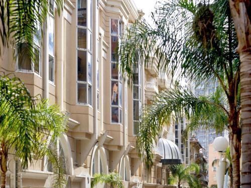 a building with palm trees in front of it at Aparthotel Adagio Monaco Palais Joséphine in Beausoleil