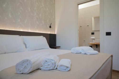 a white bed with towels on top of it at Le Cantine Rooms & Luxury Space in San Mango Piemonte