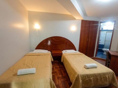 a room with two beds with towels on them at Hotel Plaza Grau in Trujillo