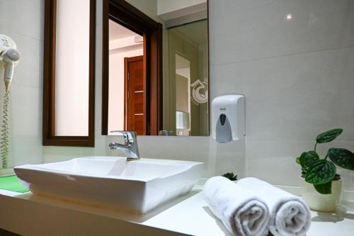 a bathroom with a white sink and a mirror at City5 ROOMS & SUITES by LSA in Skopje