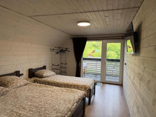two beds sitting in a room with a window at Шепіт лісу in Bukovets