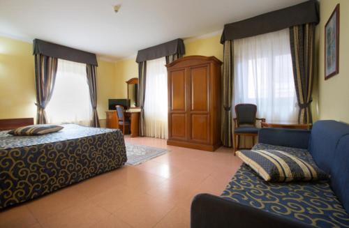 Habitación de hotel con 2 camas y sofá en Hotel Villa Ada, en Pozzallo