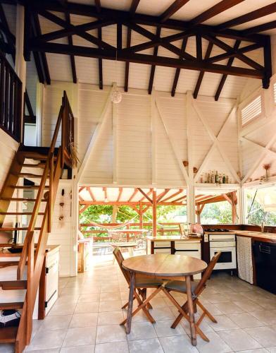 a kitchen with a wooden table and a staircase at Kazabat à Marie-Galante in Grand-Bourg
