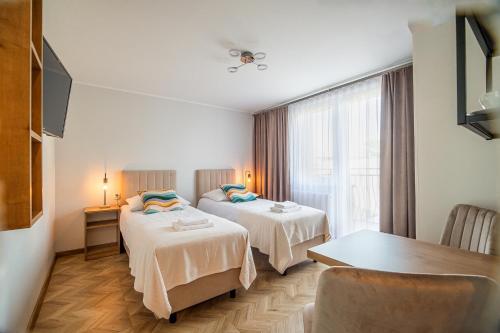 a hotel room with two beds and a table at FAMILKA in Karwia