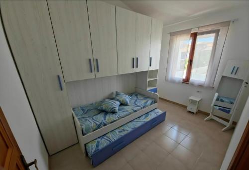 a room with a bed and cabinets and a window at Casa Iole in Budoni