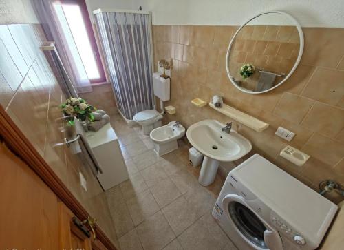 a bathroom with a sink and a toilet and a mirror at Casa Iole in Budoni