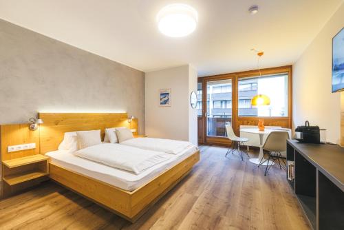 a bedroom with a bed and a table and a desk at Studio 28 Kaprun inkl Sommerkarte in Kaprun