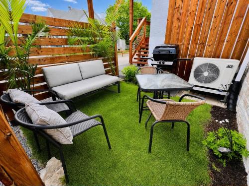 a patio with a couch and chairs and a table at L'Escapade Champlain - 2 Min Falls - Free Parking in Boischâtel