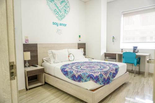 a bedroom with a bed and a blue chair at Hotel Sixtina Plaza Medellin in Medellín