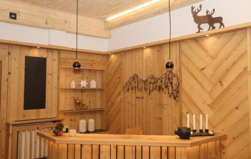 a room with a wooden wall with a table and candles at Aparthotel Ramsau in Ramsau am Dachstein