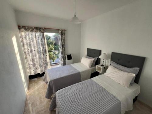 a bedroom with two beds and a window at Departamentos en Chivilcoy in Chivilcoy
