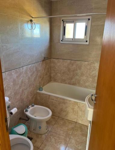 a bathroom with a tub and a toilet and a sink at Departamentos en Chivilcoy in Chivilcoy