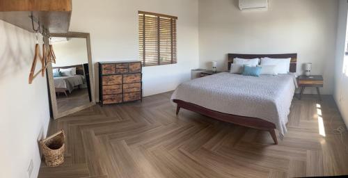 a bedroom with a bed and a large mirror at The Cottage in Saint Georgeʼs