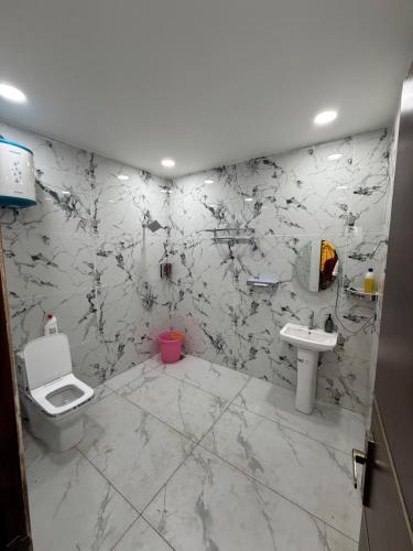 a bathroom with a toilet and a sink at oliv Faram house in Greater Noida