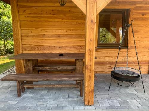 a wooden porch with a swing on a cabin at Domek letniskowy Remix in Zwierzyniec