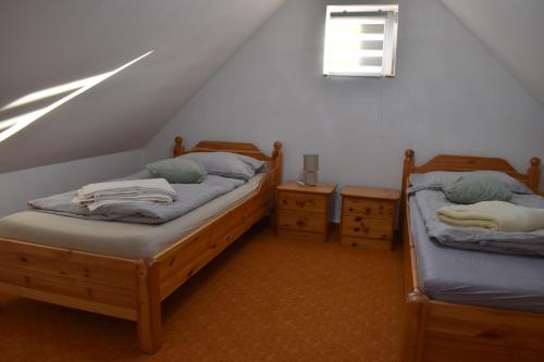 two twin beds in a room with a attic at Bozóki Apartman in Kiskunmajsa