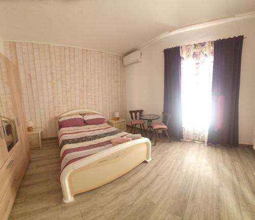 a bedroom with a bed and a table and a window at Studio à la campagne in Villanova