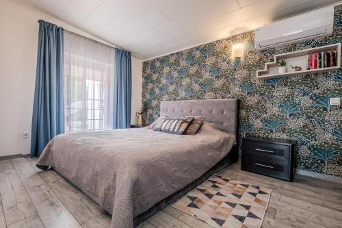 a bedroom with a bed with blue and green wallpaper at Gerika guest house in Palanga