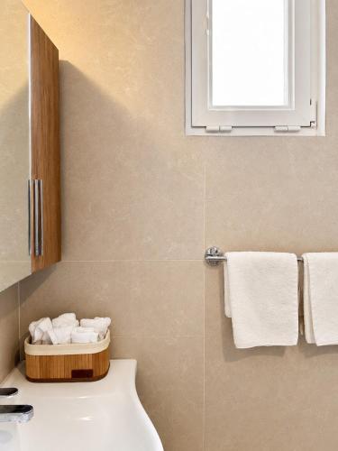 a bathroom with a toilet and a sink and towels at Milla Terrace Apartment Volos in Volos