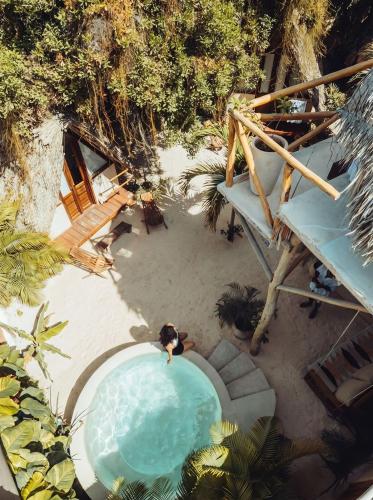 an overhead view of a swimming pool on a beach at Casa Balam Holbox, Beach style cabañas in Holbox Island