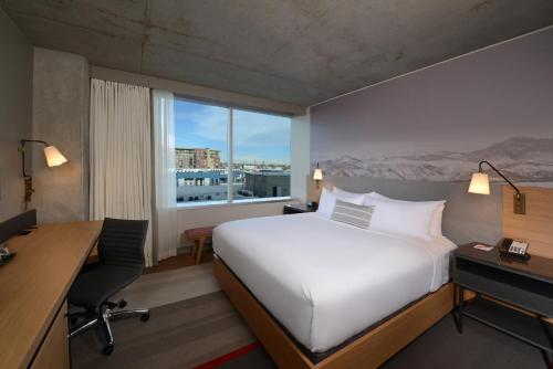 a hotel room with a bed and a desk and a window at Hotel Indigo Denver Downtown - Union Station by IHG in Denver