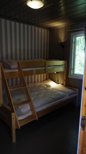 a bedroom with two bunk beds and a window at HagestadHytteutleie Wallhall in Birkenes