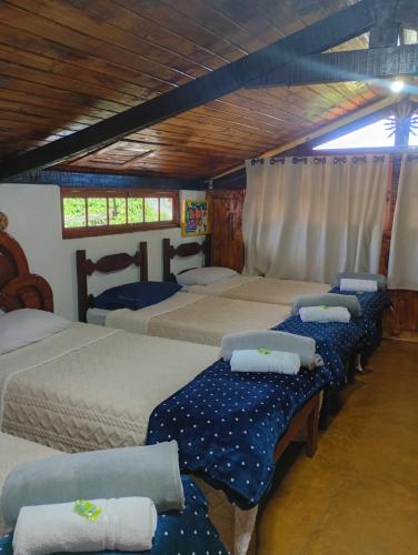 a group of four beds in a room at Dexa Hospedagem in Ouro Preto