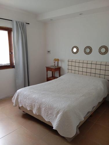 a bedroom with a white bed and two clocks on the wall at Posada San Pedro in Concordia