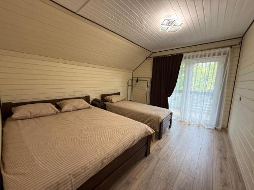 a bedroom with two beds and a window at Family House in Izki